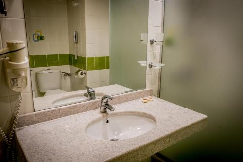 a bathroom counter with a sink and a mirror at Hotel Gergana - Ultra All Inclusive in Albena