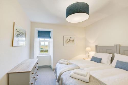 a bedroom with two beds and a desk in it at Blairinnie in Castle Douglas