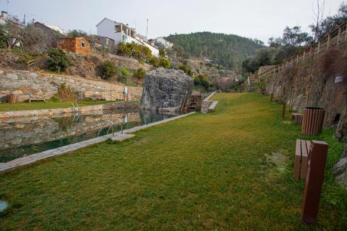 a large field of grass next to a wall at Monte das Cerejas in Montes da Senhora