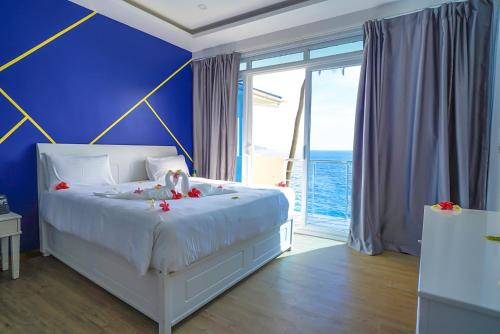a bedroom with a white bed and a blue wall at Golden Tulip Grande Comore Moroni Resort & Spa in Moroni
