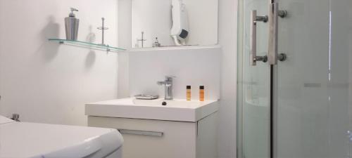 a white bathroom with a sink and a shower at Little Suite - Jeanne in Lille