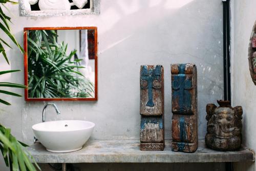 bagno con lavandino e specchio di Rumah Paros & Gallery a Sukawati