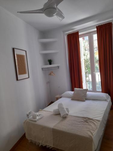 1 dormitorio con 1 cama grande y ventilador de techo en Espoz habitaciones, en Madrid