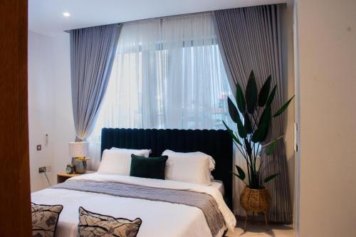 sypialnia z dużym łóżkiem i dużym oknem w obiekcie Blue Bee 2 Bedroom Apartment w mieście Lagos