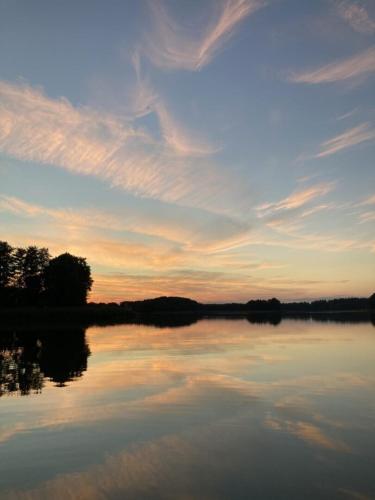 a large body of water with a sunset in the background at Cisy Resort-bon turystyczny,,ogrodzony teren na wyłączność,150 m od jeziora in Makosieje