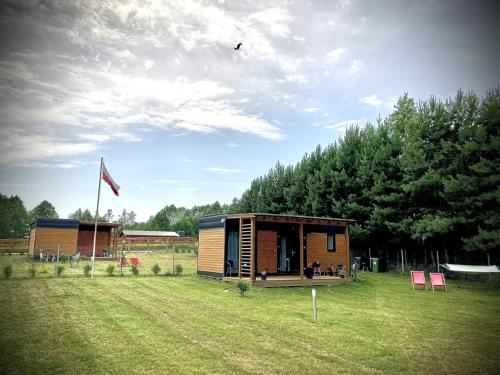 a small cabin in the middle of a field at Cisy Resort-bon turystyczny,,ogrodzony teren na wyłączność,150 m od jeziora in Makosieje