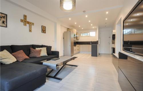 a living room with a black couch and a kitchen at Amazing Apartment In Cannes With Wifi in Cannes
