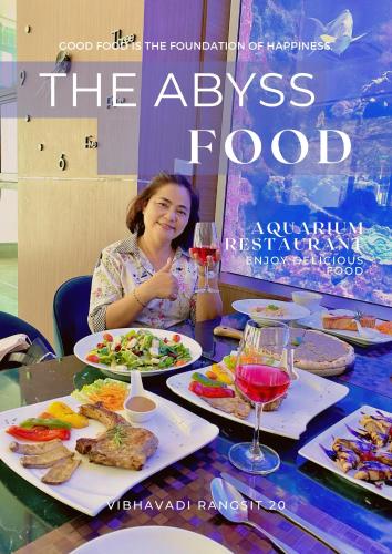 a woman sitting at a table with plates of food at V20 Boutique Jacuzzi Hotel in Bangkok