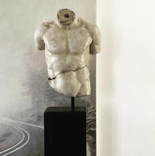 a statue of a torso on a stand in a museum at Pescallo Apartments in Bellagio
