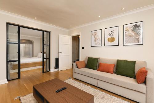 uma sala de estar com um sofá e uma mesa em PenthouseStays Chelsea - Luxury 2 Bedroom Apartment w/King Bed - near King's Road em Londres