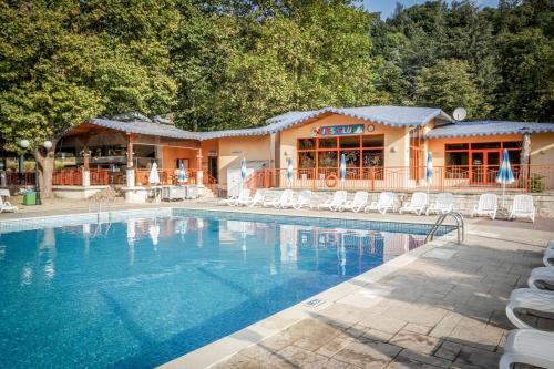 a swimming pool with chairs and a building at Kaliakra Beach Hotel - Ultra All Inclusive in Albena