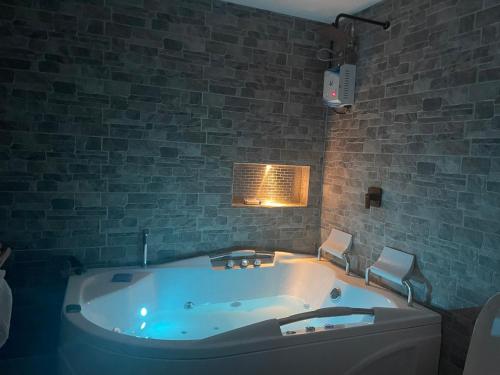 eine Badewanne in einem Zimmer mit Ziegelwand in der Unterkunft Apartasol Luxury Citadela di Sole con Jacuzzi in Santa Fe de Antioquia