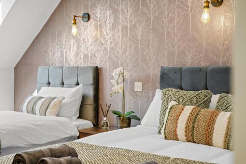 a bedroom with two beds and pink wallpaper at PRIME 3 BED HOUSE to BICESTER OUTLET for 8 People by Platinum Key Properties in Bicester