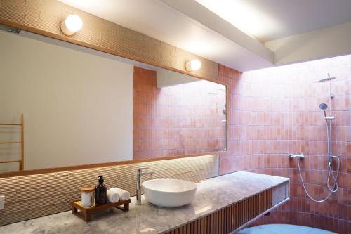 een badkamer met een wastafel en een spiegel bij Villa Panalai in Nakhon Nayok