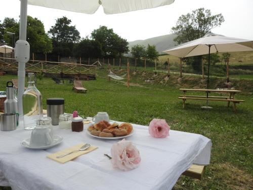 - une table blanche avec un plateau de pâtisseries dans l'établissement La Fattoria dei Sibillini, à Montemonaco