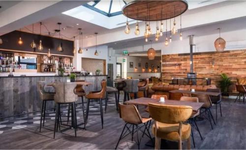 a restaurant with tables and chairs and a bar at Lake View Lodge in Saint Columb Major