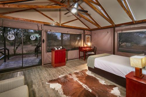 a bedroom with a bed in a tent at Manong Game Lodge in Gaborone