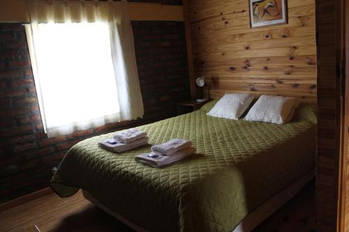 um quarto com uma cama com duas toalhas em Los Teros em Esquel