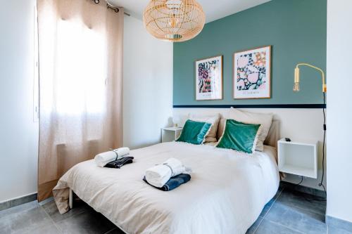 een slaapkamer met een groot wit bed met groene accenten bij Havre de nature Provence in Morières-lès-Avignon