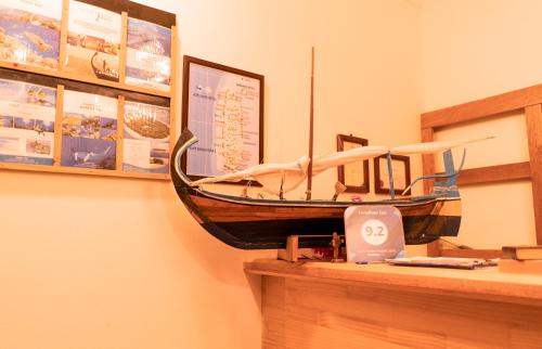 a wooden boat hanging on a wall next to a counter at Feridhoo Inn in Feridhoo