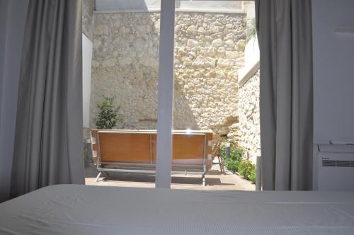 een slaapkamer met een bed en een raam met een bank bij Casa di Mario appartamento in centro storico con due camere da letto e terrazze in Cagliari