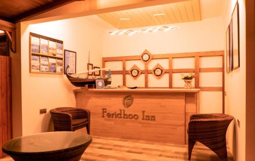 a restaurant with a bar with a table and chairs at Feridhoo Inn in Feridhoo