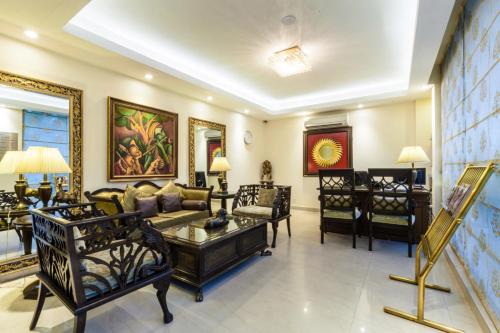 a large living room with a couch and chairs at FabHotel Goodwill GK 1 in New Delhi