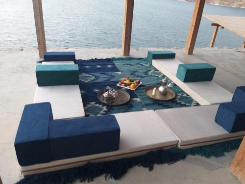 a table and chairs on a boat in the water at Mujib Chalets in Ath Thughrah