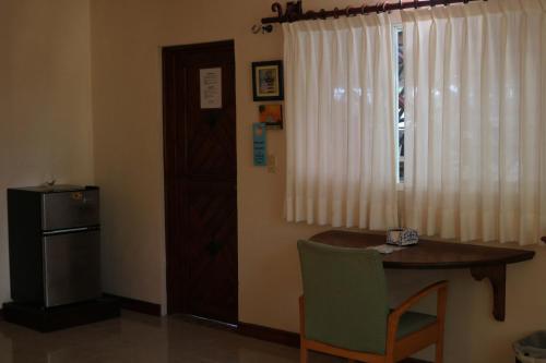 a room with a table and a window with a table and a refrigerator at The Diving Lodge Downtown in Puerto Morelos