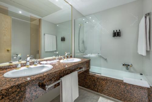 a bathroom with two sinks and a shower at Exe Boston in Zaragoza