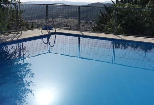 a swimming pool with a fence around it at Kampaoh Grazalema in El Bosque