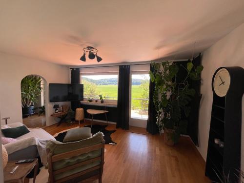 sala de estar con ventana grande y sofá en Apartment AusZeit - Natur Pur - mitten im Grünen, 