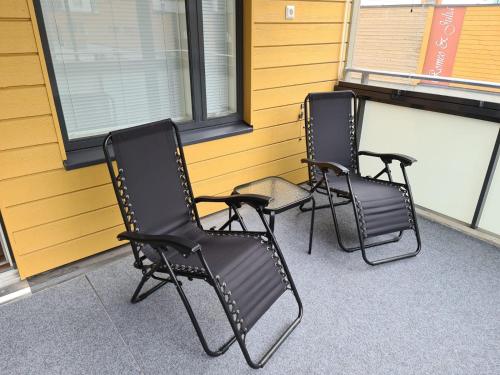 drei schwarze Stühle vor einem Gebäude in der Unterkunft MR Apartments 2 in Vaasa