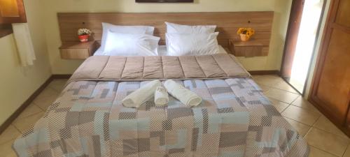 uma cama com duas almofadas num quarto em Hotel Shangrila Nova Friburgo em Nova Friburgo
