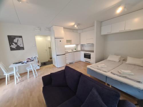 a room with a bed and a couch and a table at MR Apartments 2 in Vaasa