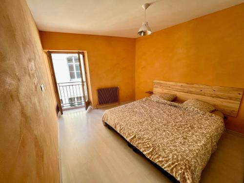 een slaapkamer met een bed met een houten hoofdeinde en een raam bij Appartement 2 chambres - lits king size - wifi - baignoire in Le Puy en Velay