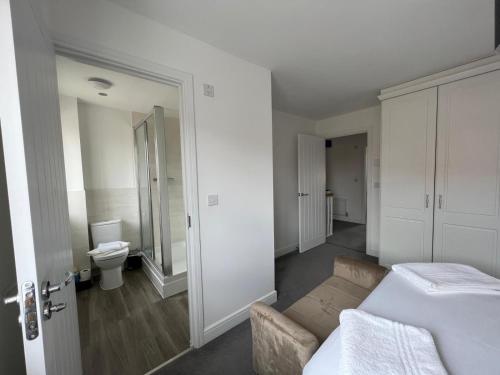 biała sypialnia z łóżkiem i toaletą w obiekcie Spacious & Stylish 4-Bed House with Hot Tub in Prime Location w Southampton
