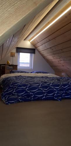 Gîte pour 2 في Wingen: سرير كبير في غرفة ذات سقف خشبي