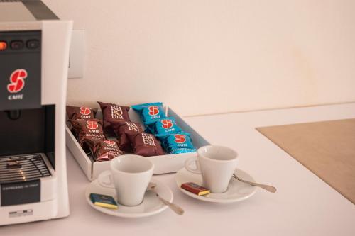 a table with two cups of coffee and a box of chocolates at ViaNettuno in Civitanova Marche