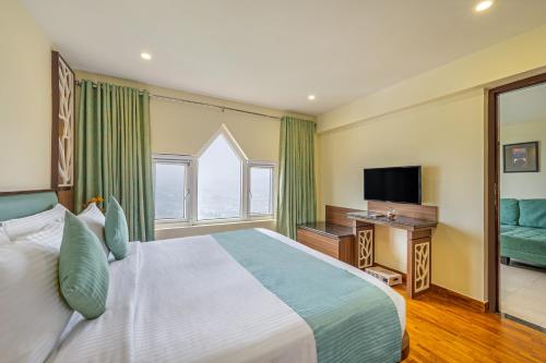 a hotel room with a bed and a television at Sterling Ooty Elk Hill in Ooty