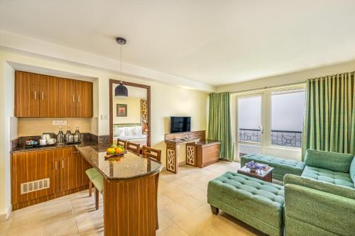 a kitchen and living room with a couch and a table at Sterling Ooty Elk Hill in Ooty