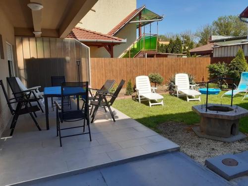 d'une terrasse avec des chaises, une table et un foyer extérieur. dans l'établissement Nyárfa Vendégház, à Hajdúszoboszló