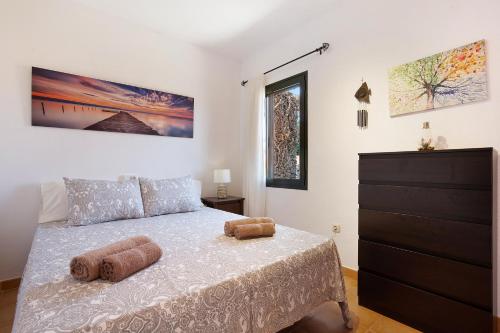 ein Schlafzimmer mit einem Bett mit zwei Kissen darauf in der Unterkunft Casa Yoaki in Corralejo