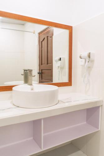 a bathroom with a white sink and a mirror at Feridhoo Inn in Feridhoo