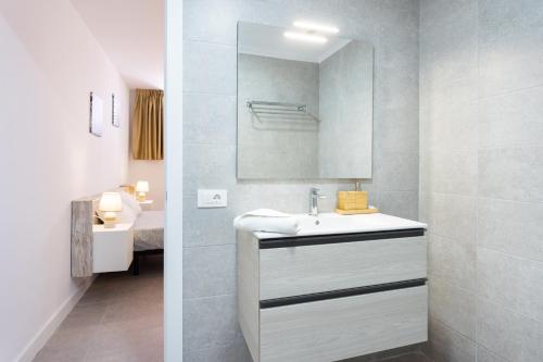 ein Badezimmer mit einem weißen Waschbecken und einem Spiegel in der Unterkunft 120 PLAYA DE LA ARENA Holiday Home by Sunkeyrents in Puerto de Santiago