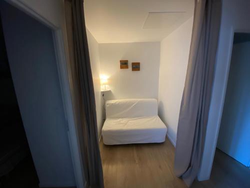 a small room with a white bed and a window at Appartement Saika et les Hirondelles in La Fouillade