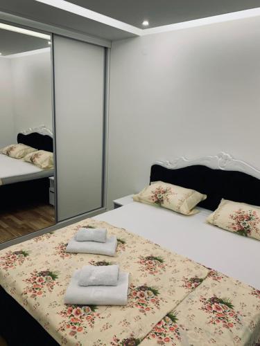 1 dormitorio con 1 cama grande y toallas. en Apartman LUX en Bijeljina