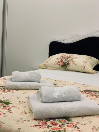 Una cama con tres toallas encima. en Apartman LUX en Bijeljina