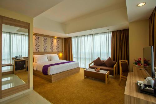 ブカシにあるホテル ホライゾン ウルティマ ブカシのベッドとソファ付きのホテルルーム