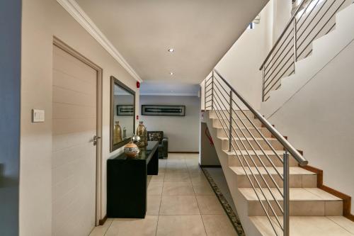 a hallway of a house with stairs and a mirror at Regent Kgale Lodge in Gaborone